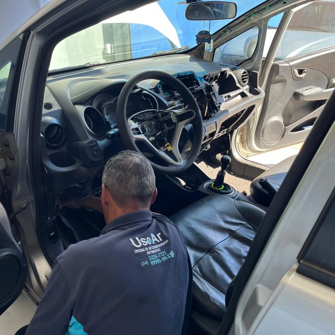 Técnico realizando manutenção interna no painel do veículo